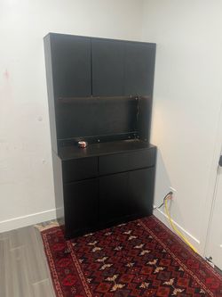 Free standing cabinet with drawers and a light.
