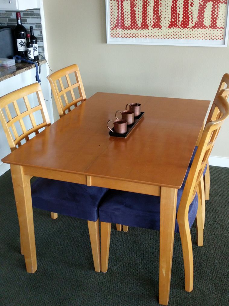 Dining table with hiding/fold-under leaf and 4 chairs.