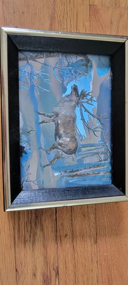 vintage Dufex foil print featuring a caribou stag in a winter snow scene.The artwork is known for its iridescent silver and blue coloring.