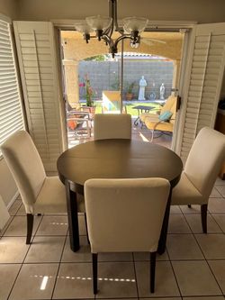 Round extendable dining room table with 4 chairs.
