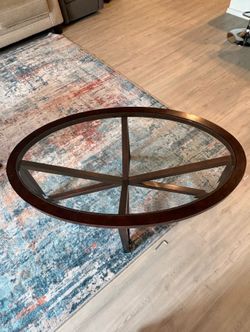 Oval glass top table with interlocking X-shape legs