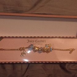 gold-tone Juicy Couture Heritage Collection charm bracelet with blue and gold charms. 
