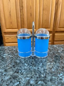 Vintage Hard Plastic Blue  Pair of Salt and Pepper Shakers with holder.  Size approximately 3 1/4 inches tall.  Preowned never used .