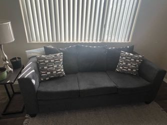 Navy blue fabric couch with pillows