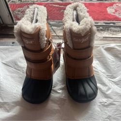 Warm kids snow boots with a tan upper and black waterproof lower.