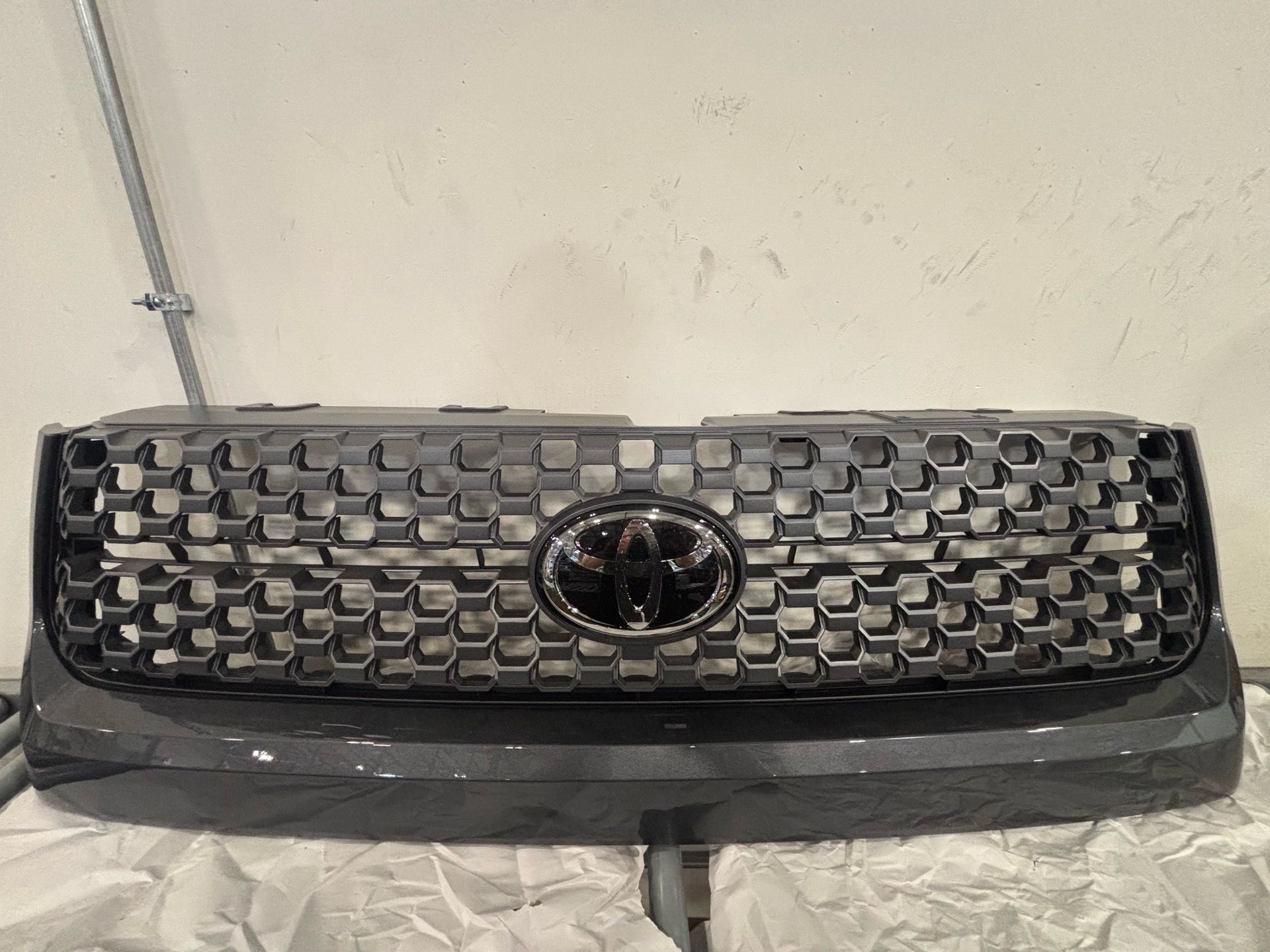 Genuine OEM Toyota Tundra TRD Sport honeycomb grille assembly in dark gray finish.