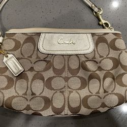 Brown Coach wristlet with signature pattern
