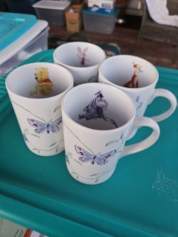 Vintage Disney Winnie the Pooh and friends ceramic mugs featuring springtime butterfly designs on the exterior.
