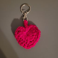 Crocheted heart keychain made with pink yarn with a metallic thread