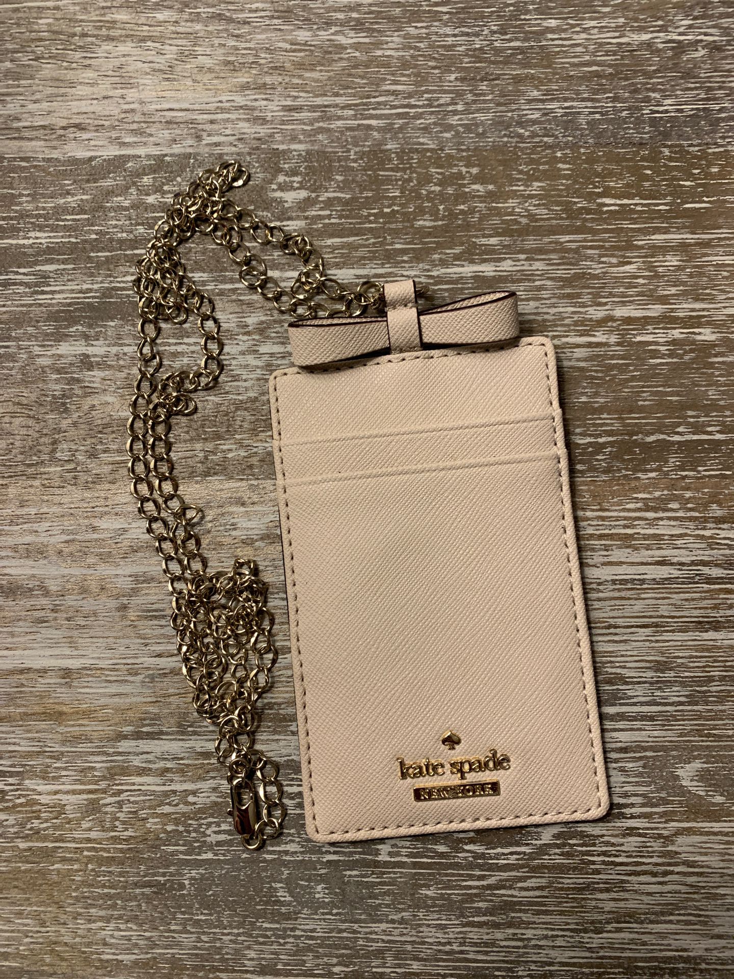 Kate Spade ID and Card holder with gold necklace.