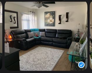 Black faux leather automatic reclining sectional.