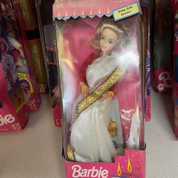 Barbie in India doll, manufactured by Leo Mattel. This specific version features the doll with blonde hair, wearing a white sari with red and gold tri
