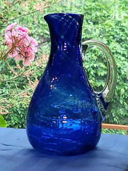 Vintage cobalt blue hand-blown crackle glass pitcher featuring a clear applied handle