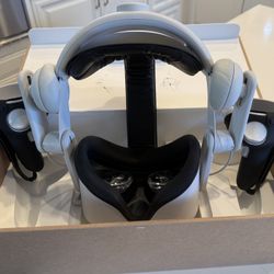 Oculus Quest 2 With Added On Headset Strap, Headphones, And Controller Grips.