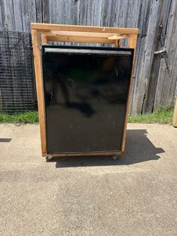 Black mini refrigerator with wooden wheels