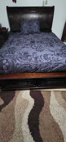 Queen size bedframe with 2 drawers on the bottom with no mattress.