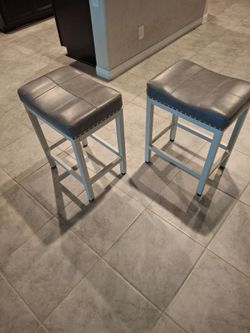 Two gray leather seat bar stools