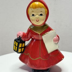 Vintage figurine of a caroling girl in a red dress