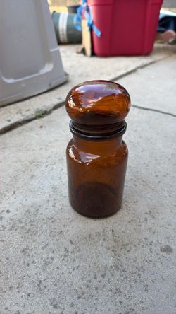 This is a vintage amber glass apothecary/canister jar with a rounded "bubble" glass lid, originally made in Belgium during the mid-20th century (often