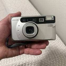 This is a Concord C2001 35mm film camera.  Equipped with a 35-70mm zoom lens with autofocus. Has a "Super Macro" function for detailed close-up shots.