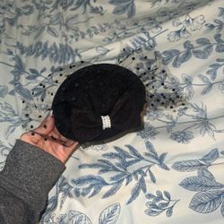 Elegant black hat with veil and bow detail.