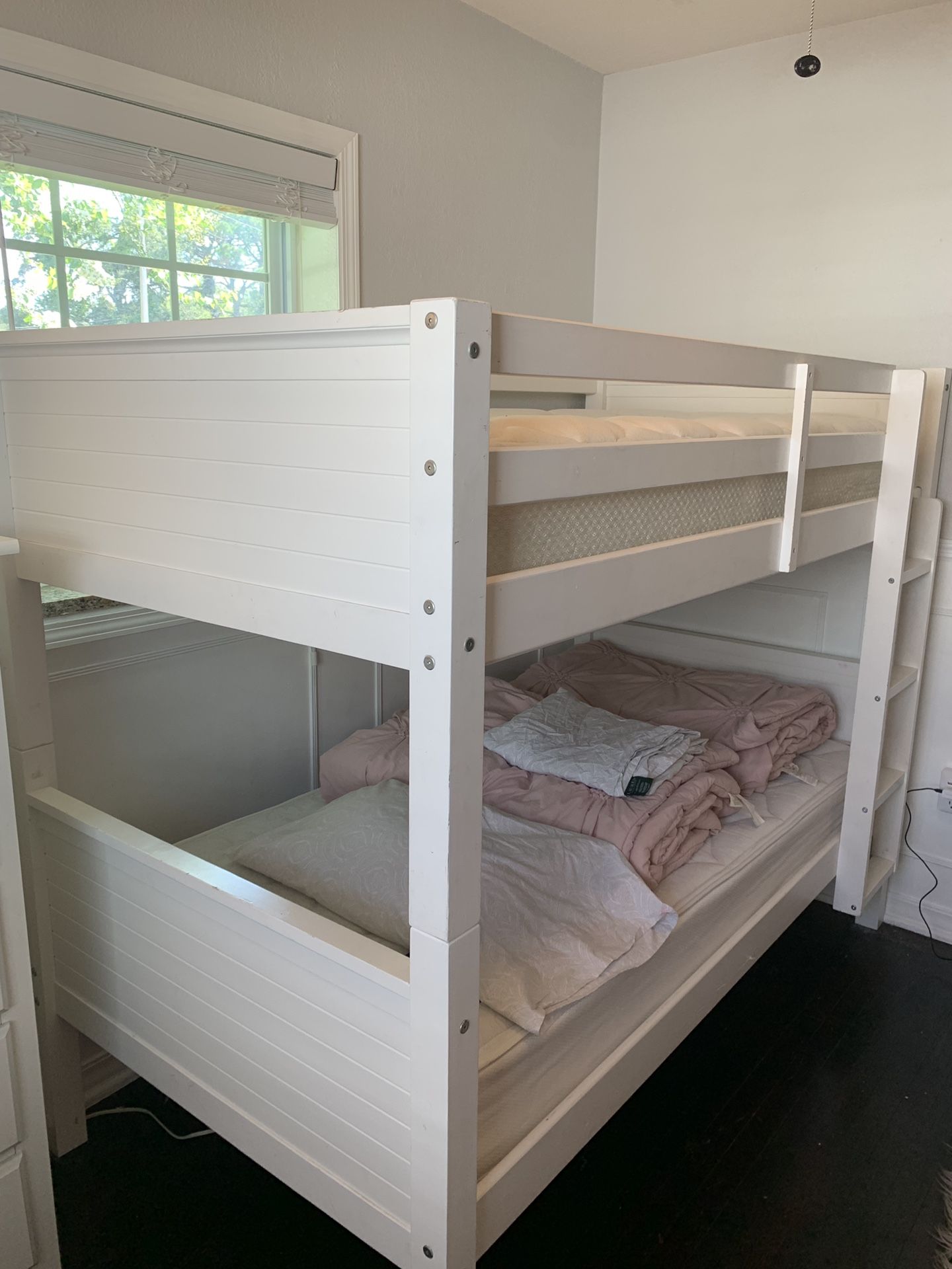 Bunk beds with mattresses, comforters and sheets.