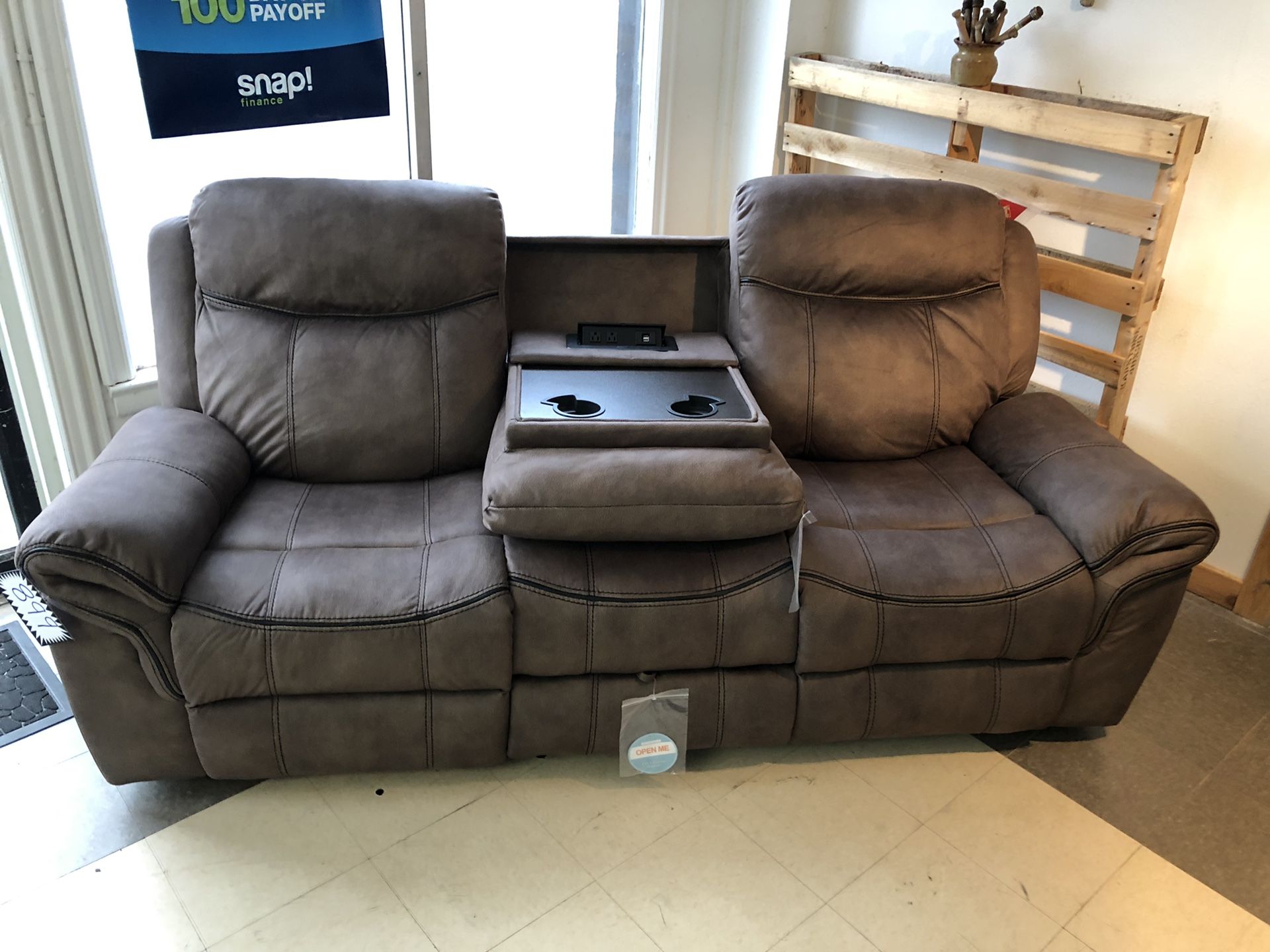 WATER RESISTANT Microfiber smooth bomber jacket material recliner. Pull out table with cup holders. Built in USB ports and wall plug ins. Hidden draw