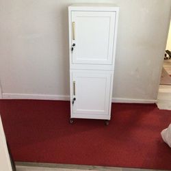 White metal storage cabinet with brass handles