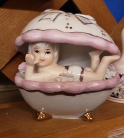 Little porcelain baby girl in shell bathtub
