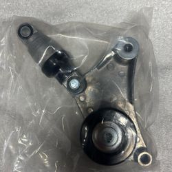 Belt tensioner with pulley assembly