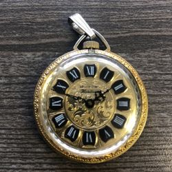 American Heritage Swiss made pocket watch pendant 1 1/2” diameter with gold scroll finish. works & keeps good time.