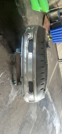 original heavy-duty steel front bumper assembly with the integrated black top step pad and factory tow/fog hook cutouts.