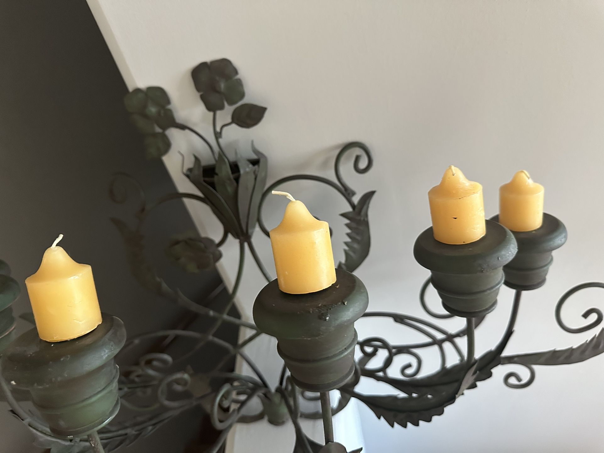 Decorative wrought iron candle holder with six yellow candles. 