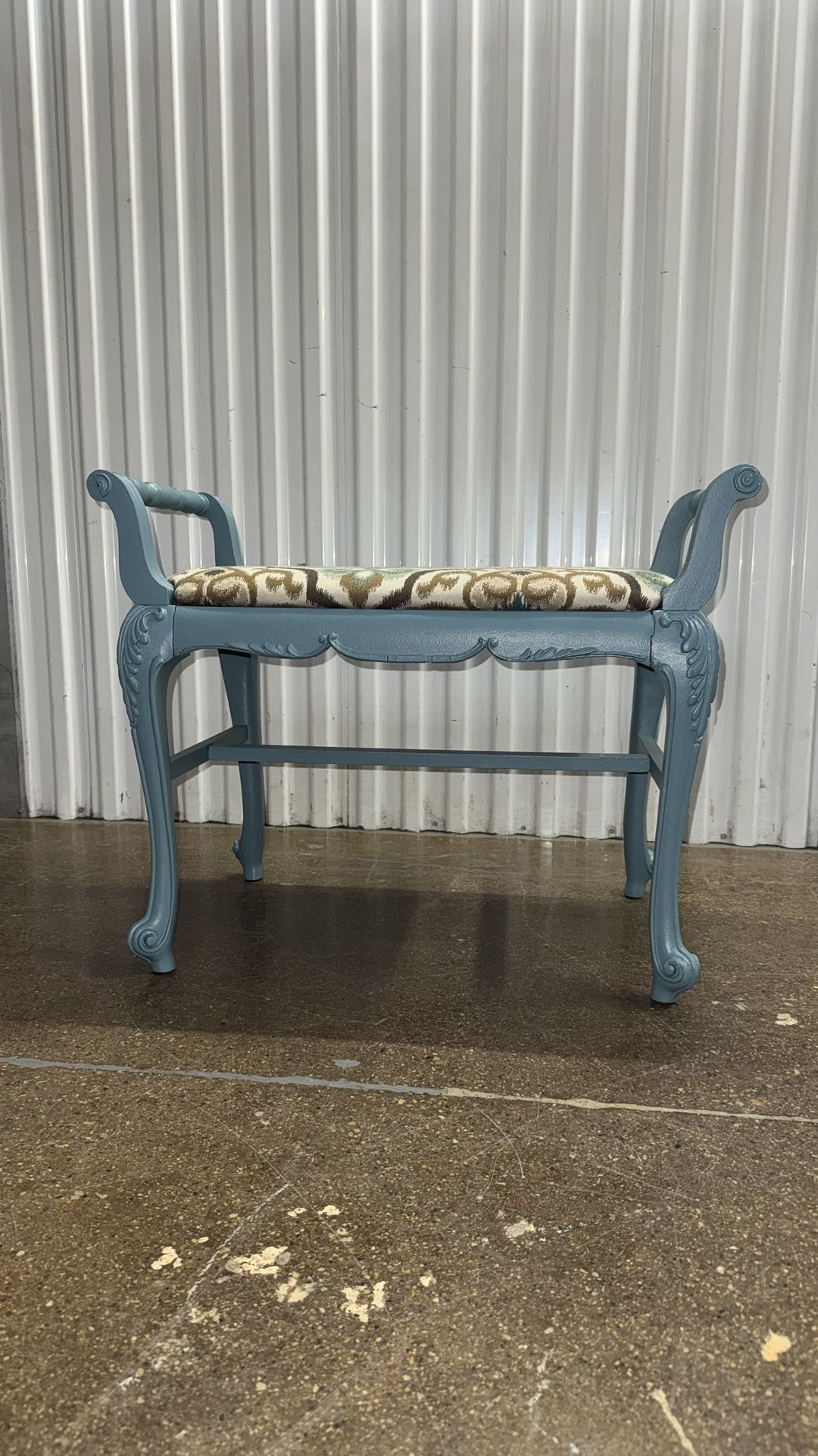 vintage distressed wooden vanity stool with upholstered seat in light blue, multicolor ikat fabric