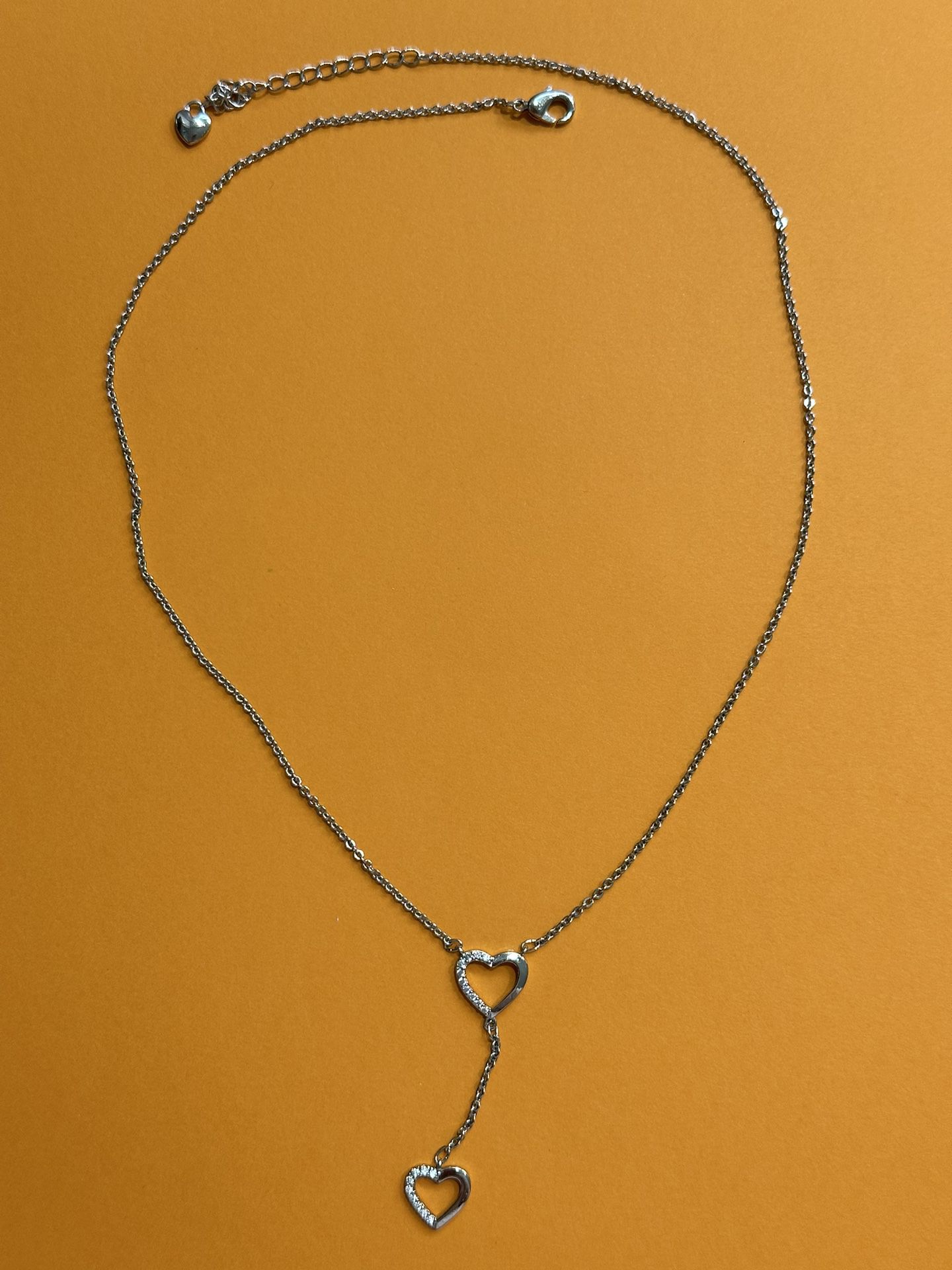 Silver tone dainty dangling hearts necklace.