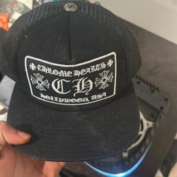 Chrome Hearts CH Hollywood Trucker Hat. This popular streetwear accessory features a signature black mesh back and a structured front panel with a lar