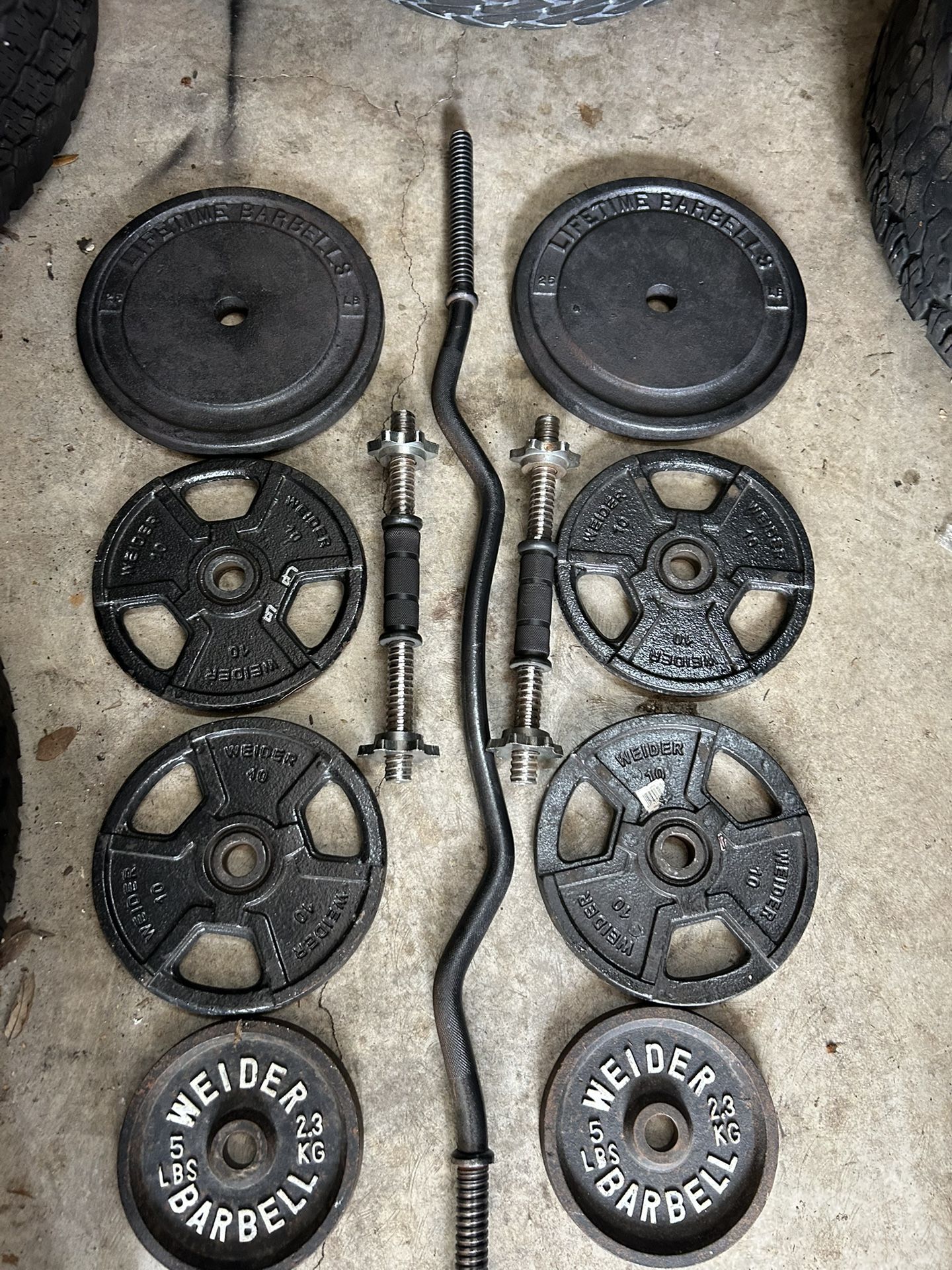 100lbs of standard 1 inch plates with ez curl bar and dumbbell bars