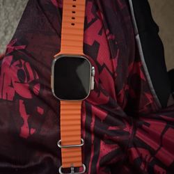 Apple Watch Ultra 2 with an orange Ocean Band. 