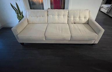 White sofa. Three tufted back cushions.