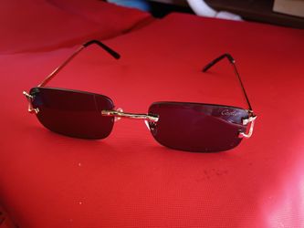 Cartier mens sunglasses black rimless lenses with gold frames.