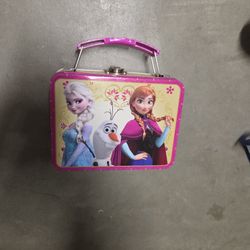 This is a Disney's Frozen embossed tin lunch box featuring the characters Elsa, Anna, and Olaf.