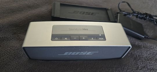 Bose SoundLink Mini portable Bluetooth speaker along with its original charging cradle and wall power adapter