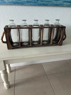 Rustic wood rack with five bottles and rope handles