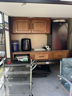 2015 Surveyor with bunk beds on one end of the RV and Queen bed on the other end. It has an outside kitchen and led lights on the awning and cameras.