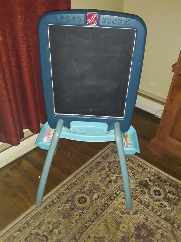 Child's Step 2 Chalkboard/Whiteboard Easel. Markers & Magnetic numbers and letters can be used on whiteboard side. Clean & in very good condition. Mar