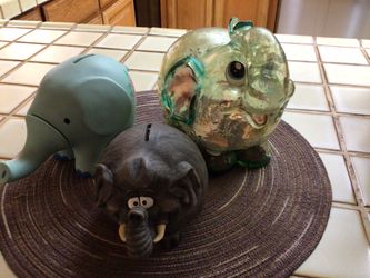Various Elephant Piggy Banks With Some Coins
