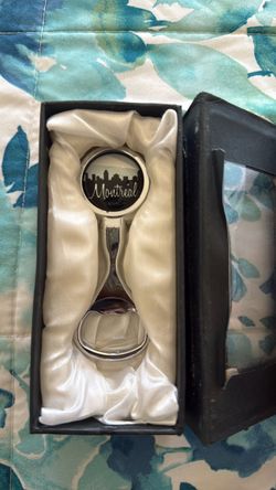 This item is a metal souvenir bottle opener featuring the skyline