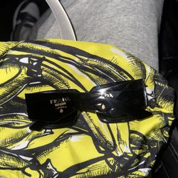 Prada PR 27ZS 16K70A sunglasses in a black frame with yellow lenses