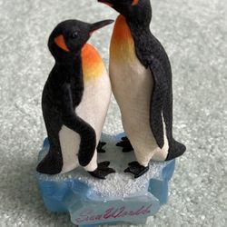 A pair of penguin figurines on a base from SeaWorld