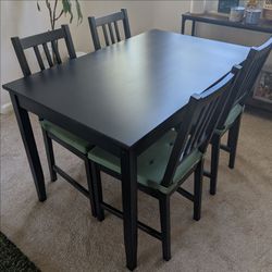 Black IKEA table and chairs with cushions